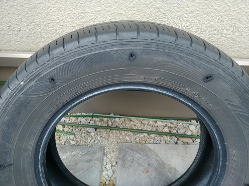 タイヤを保管する土台のタイヤに水抜き用の穴を開けた写真